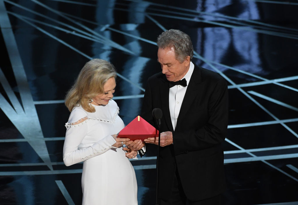 Faye Dunaway and Warren Beatty open up an envelope together on stage