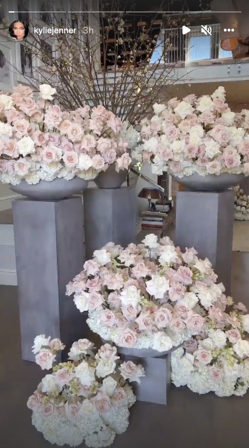Tall concrete pillars with giant bowls of roses on top