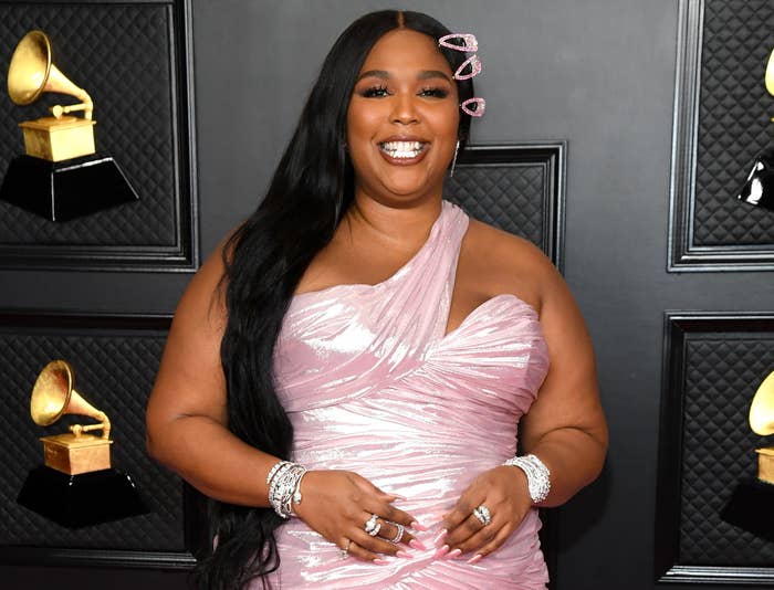Lizzo smiles on a red carpet