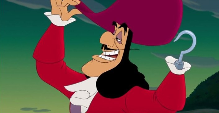 A close up of Captain Hook as he adjusts his large hat with his hook hand