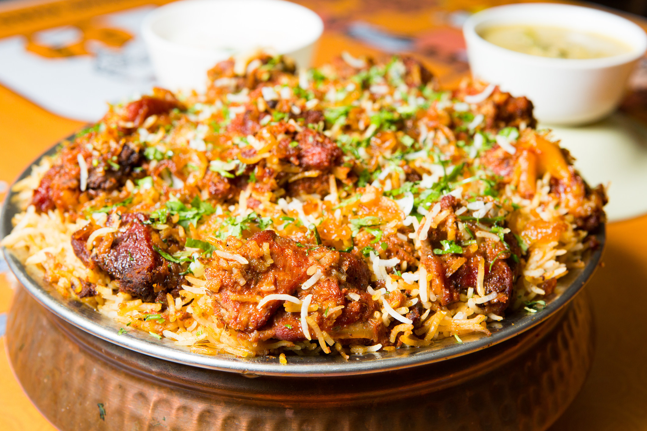 A big plate of biryani with meat.