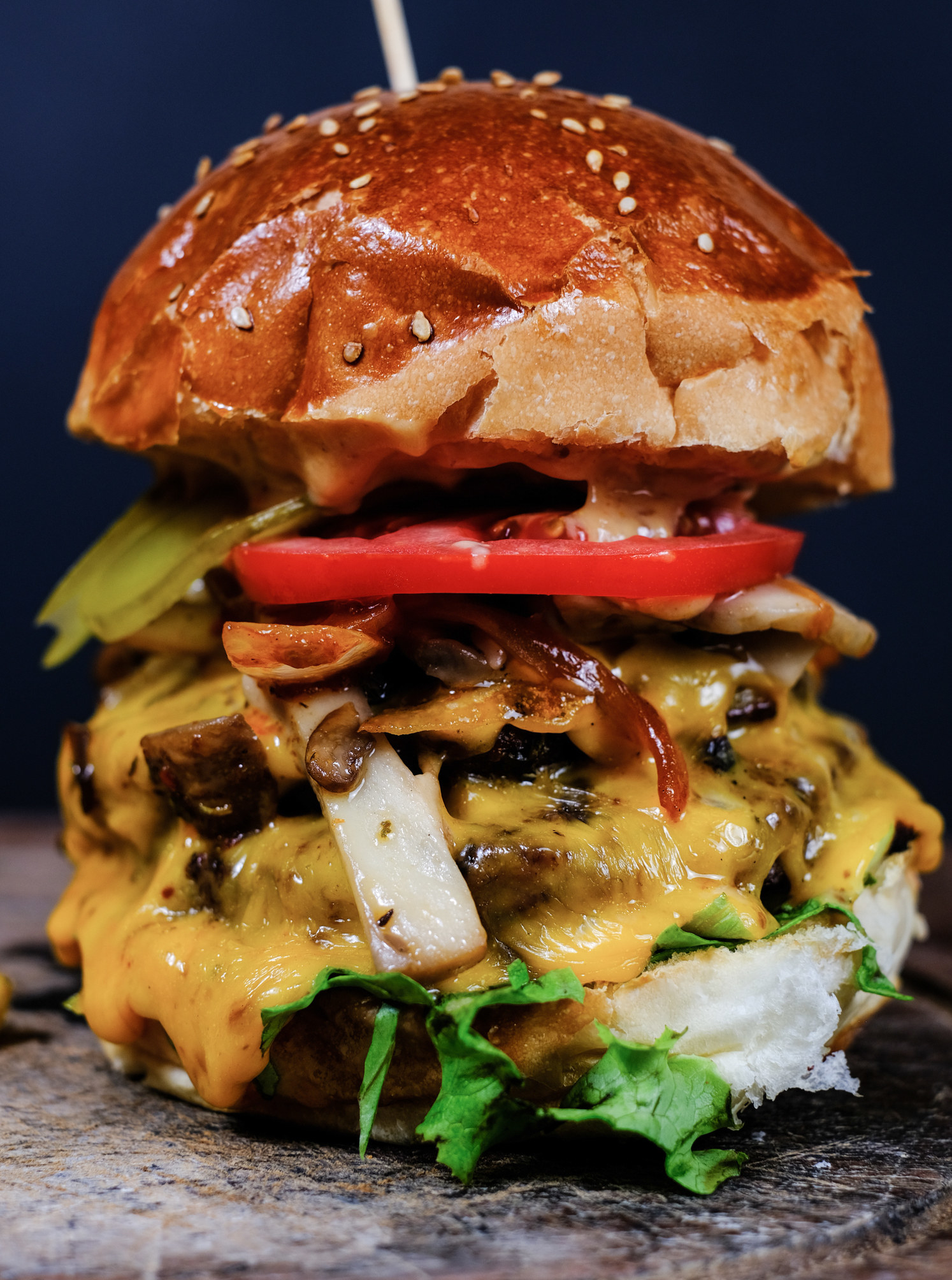 A big cheeseburger with lots of toppings.