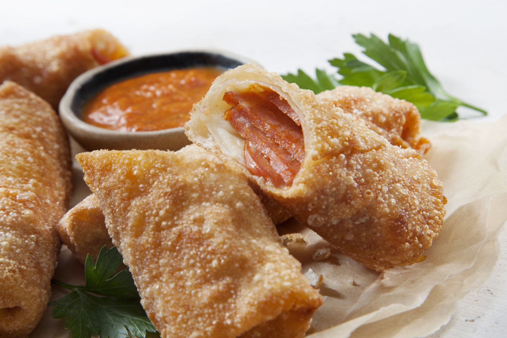 Pepperoni pizza rolls with dipping sauce.
