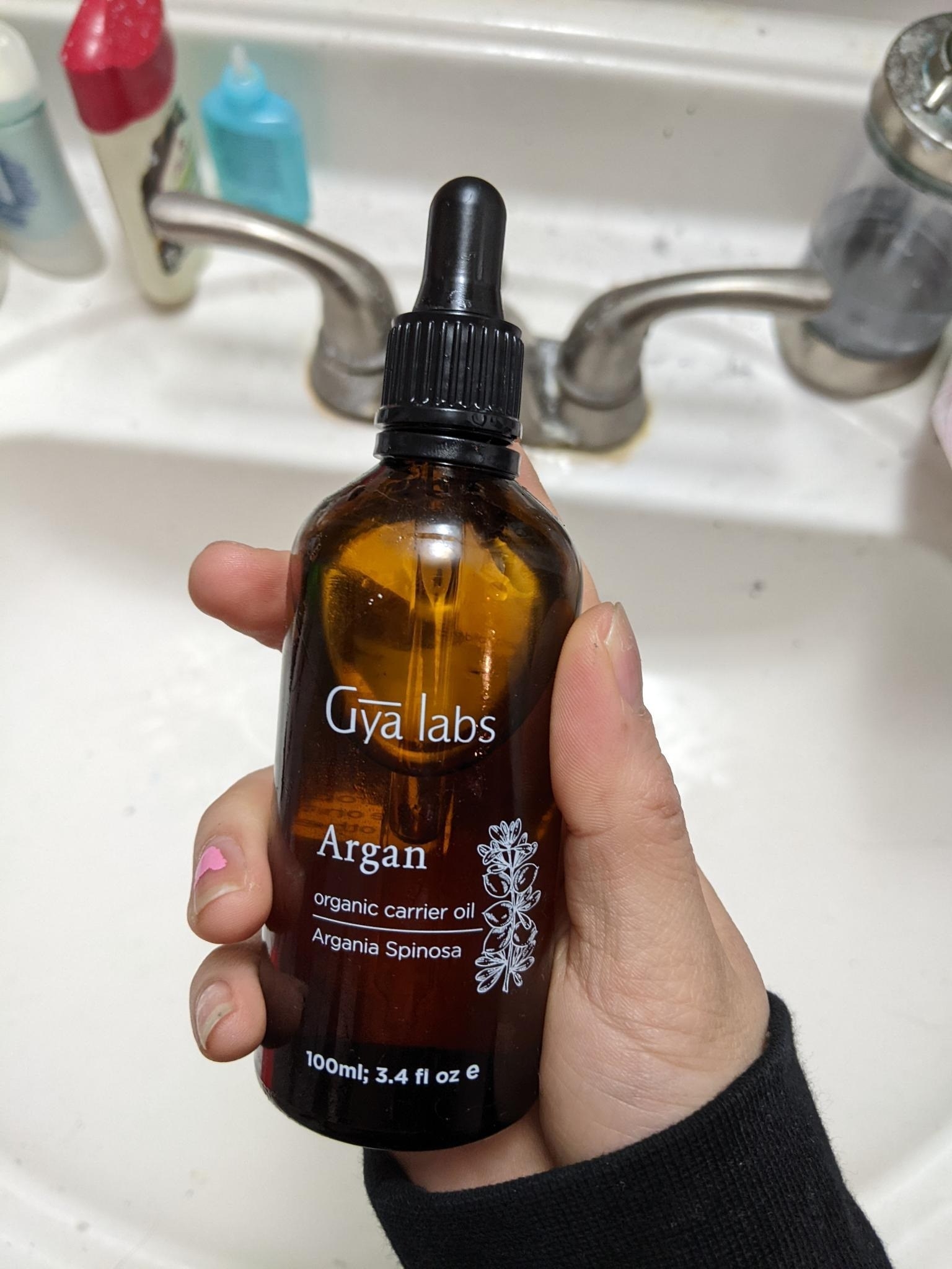 Someone holding a bottle of Gya labs argan oil