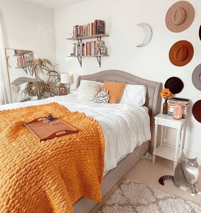 Writer's bedroom with a mustard yellow chunky knit blanket on top of their bed