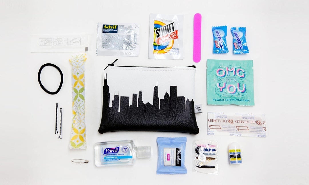 the black and white zip-top pouch surrounded by a makeup wipe, hand sanitizer, and more small provisions