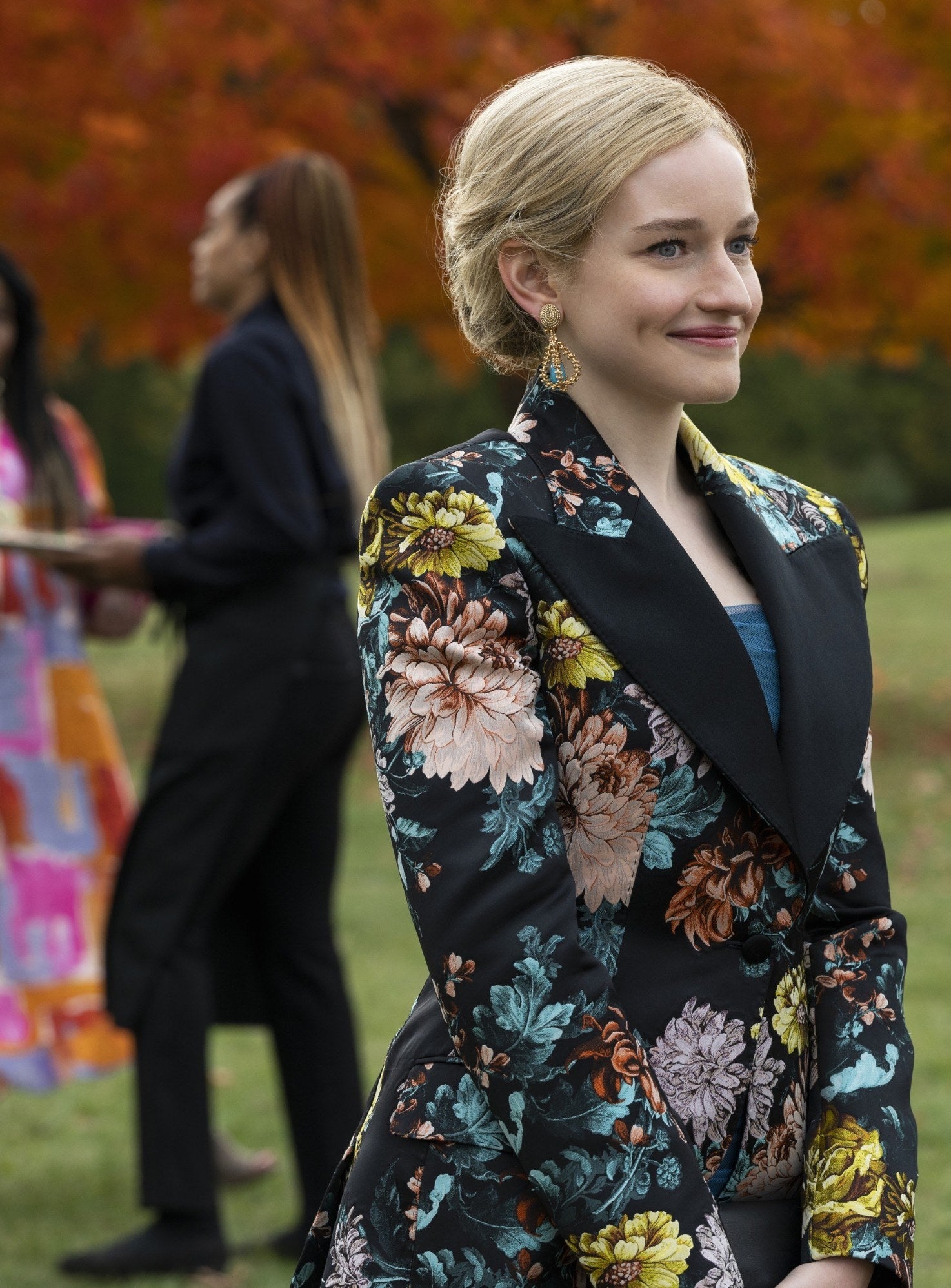 wearing a smart floral dress, Anna gives a self-satisfied smile