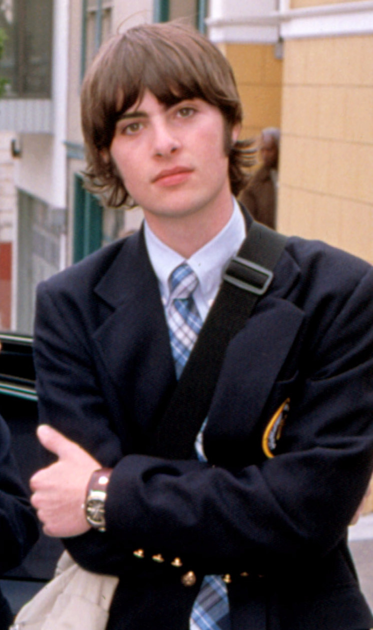 Schwartzman wearing a school uniform while folding his arms