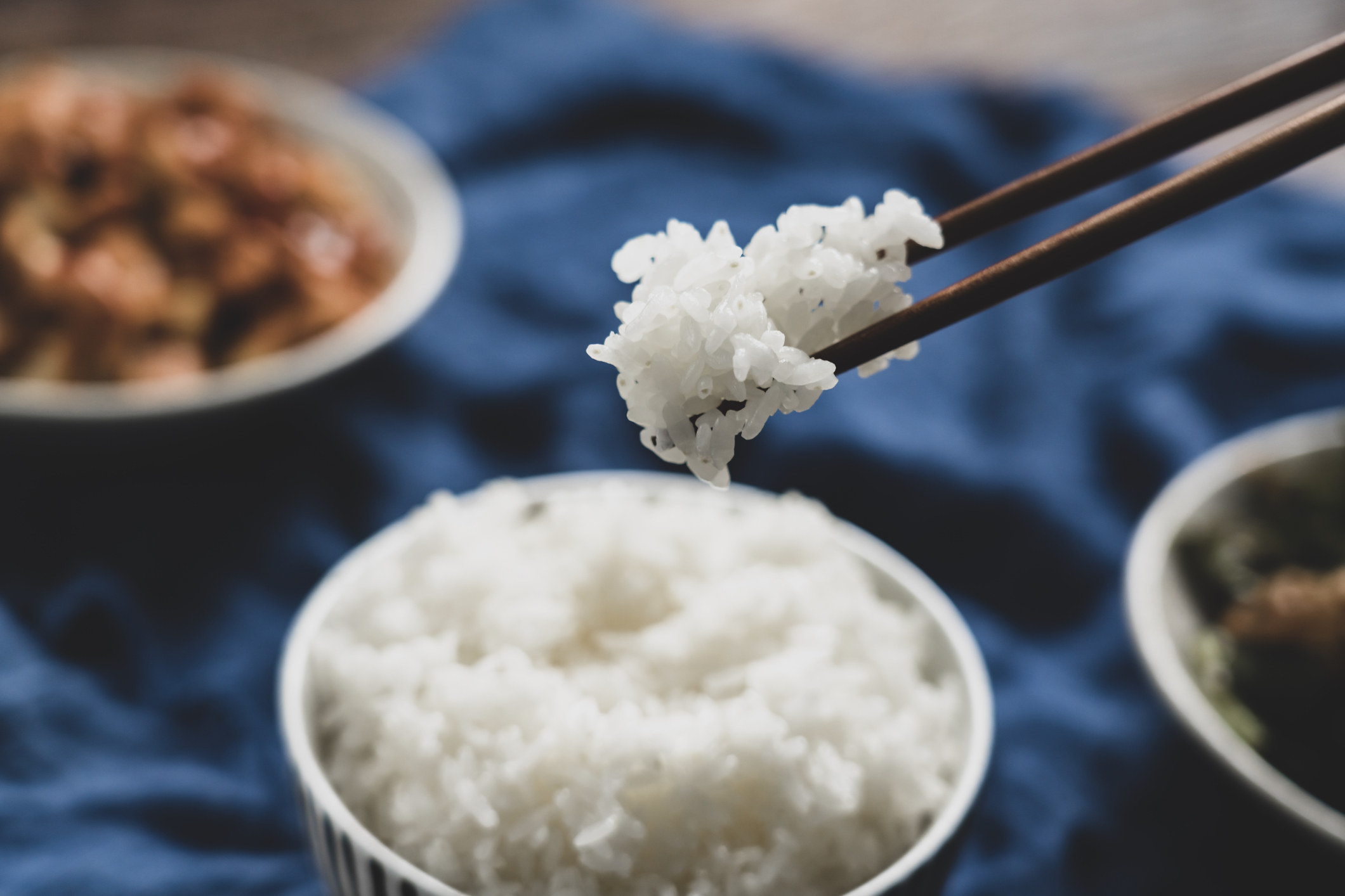 Chopsticks picking up white rice