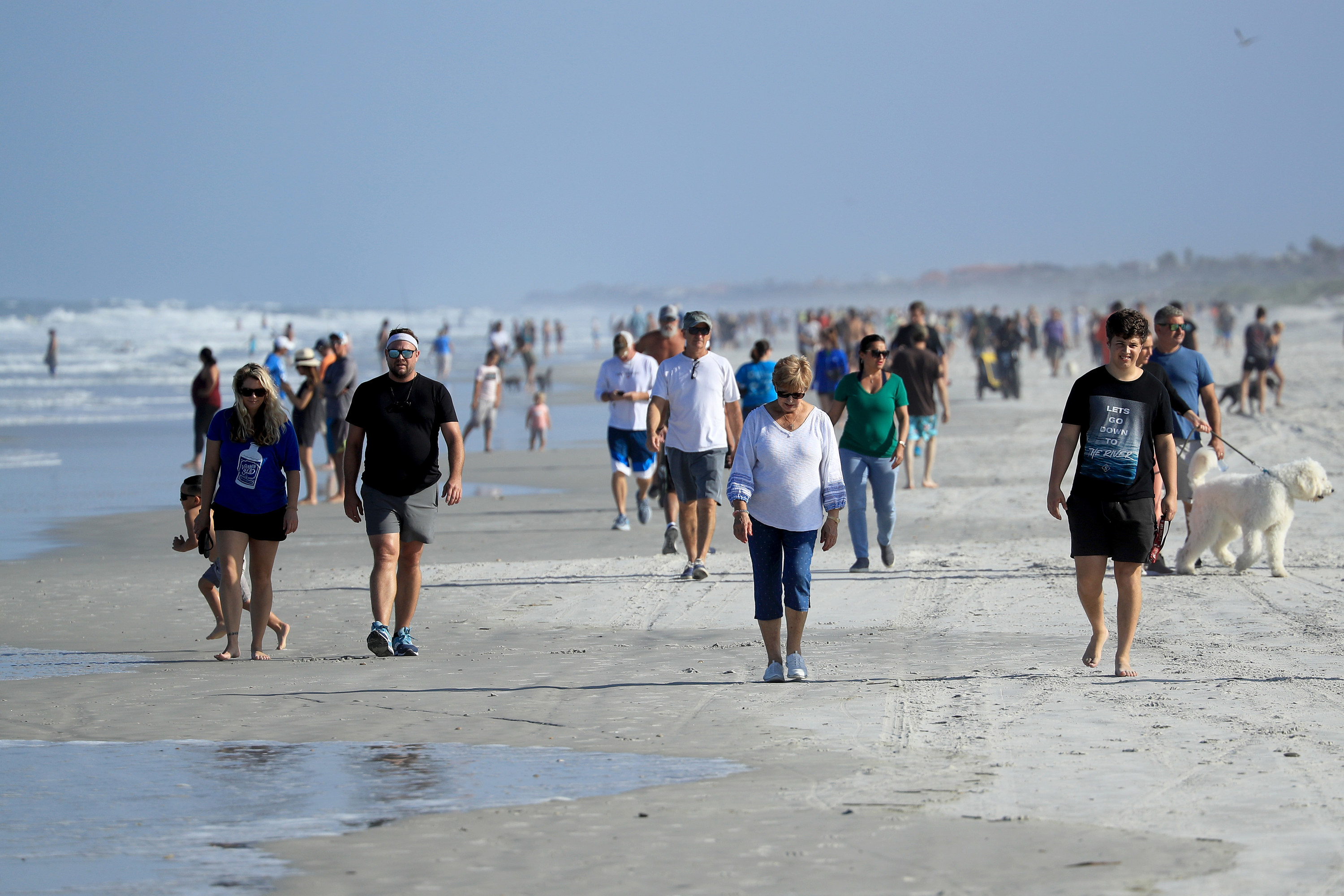 Crowd of people walking on a beach in Florida without masks