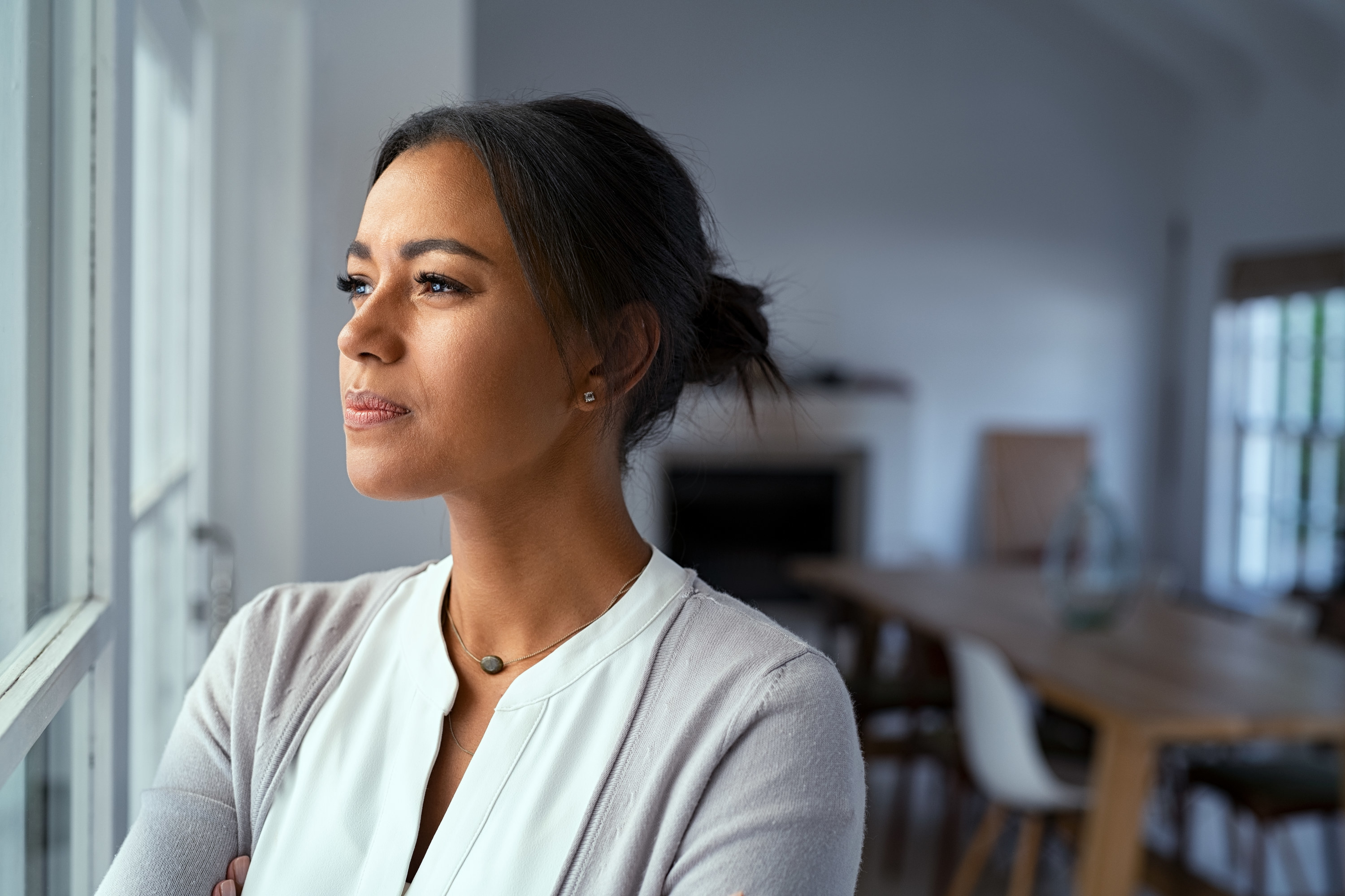 Concerned woman looks out the window