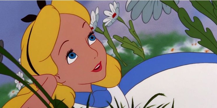 A close up of Alice as she lays in a field of daisies with one hand under her head