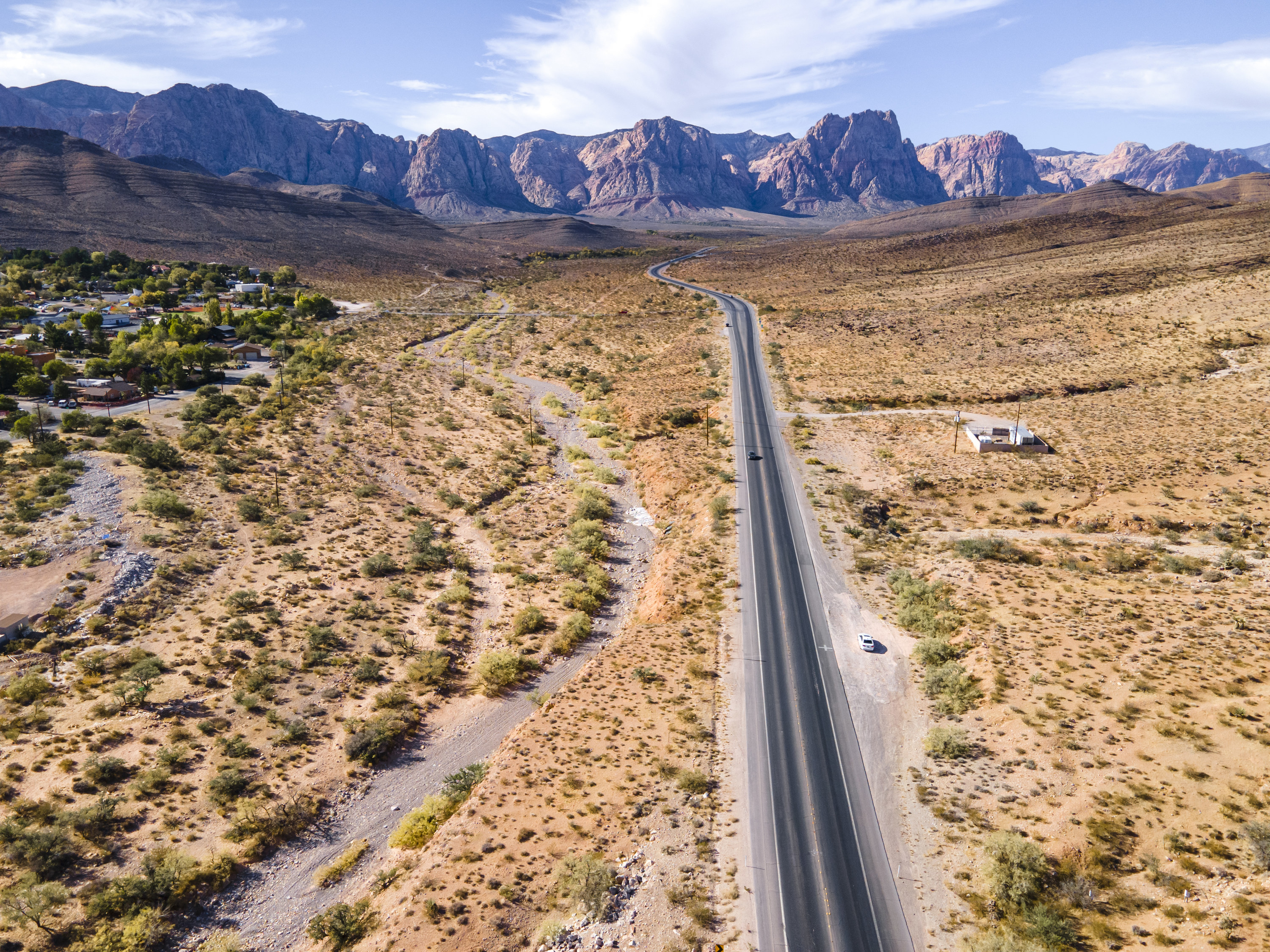 A long, windy road in a valley outside of Las Vegas, surrounded by mountains and dessert