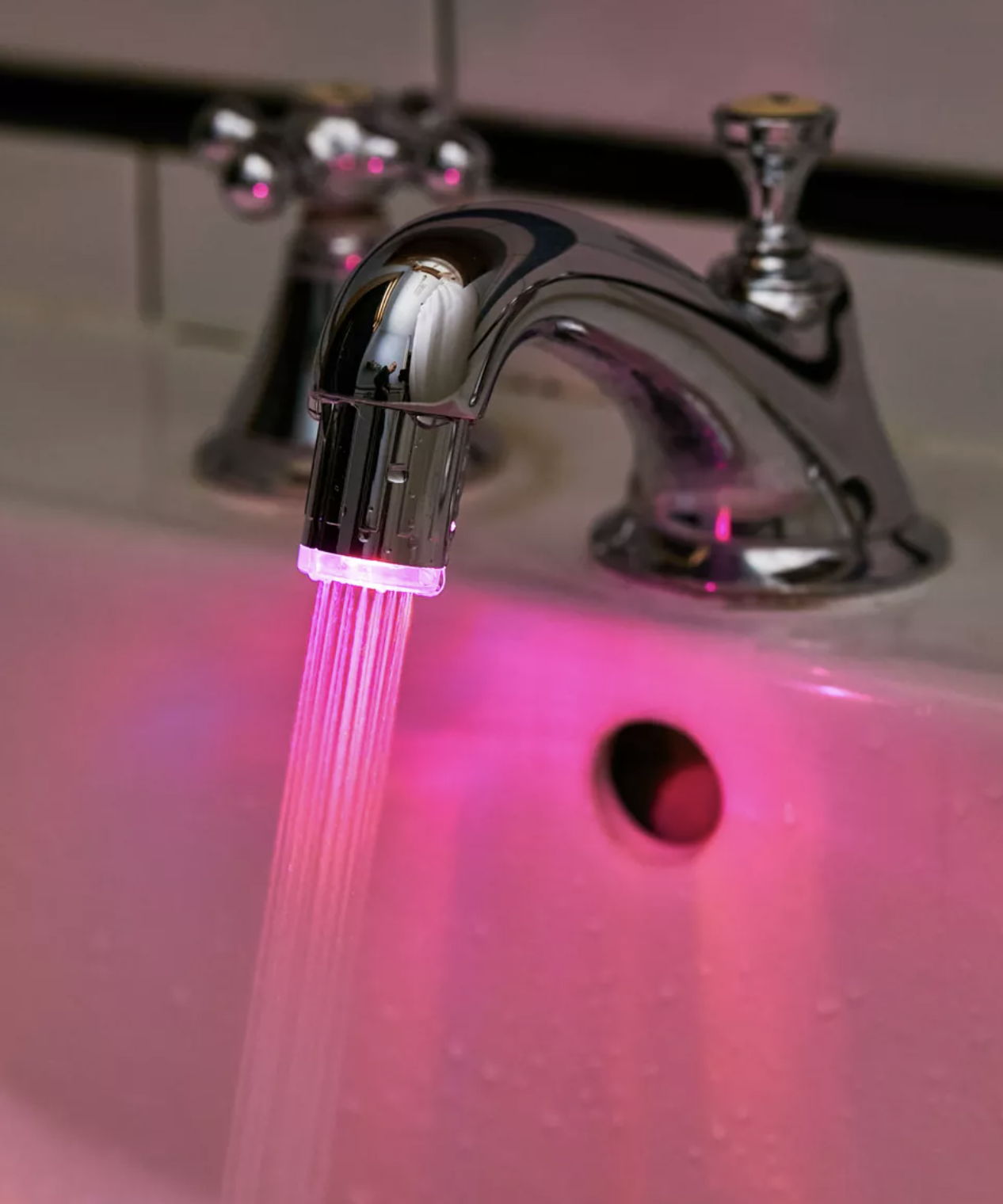 The glowing light on a faucet with water coming out of it