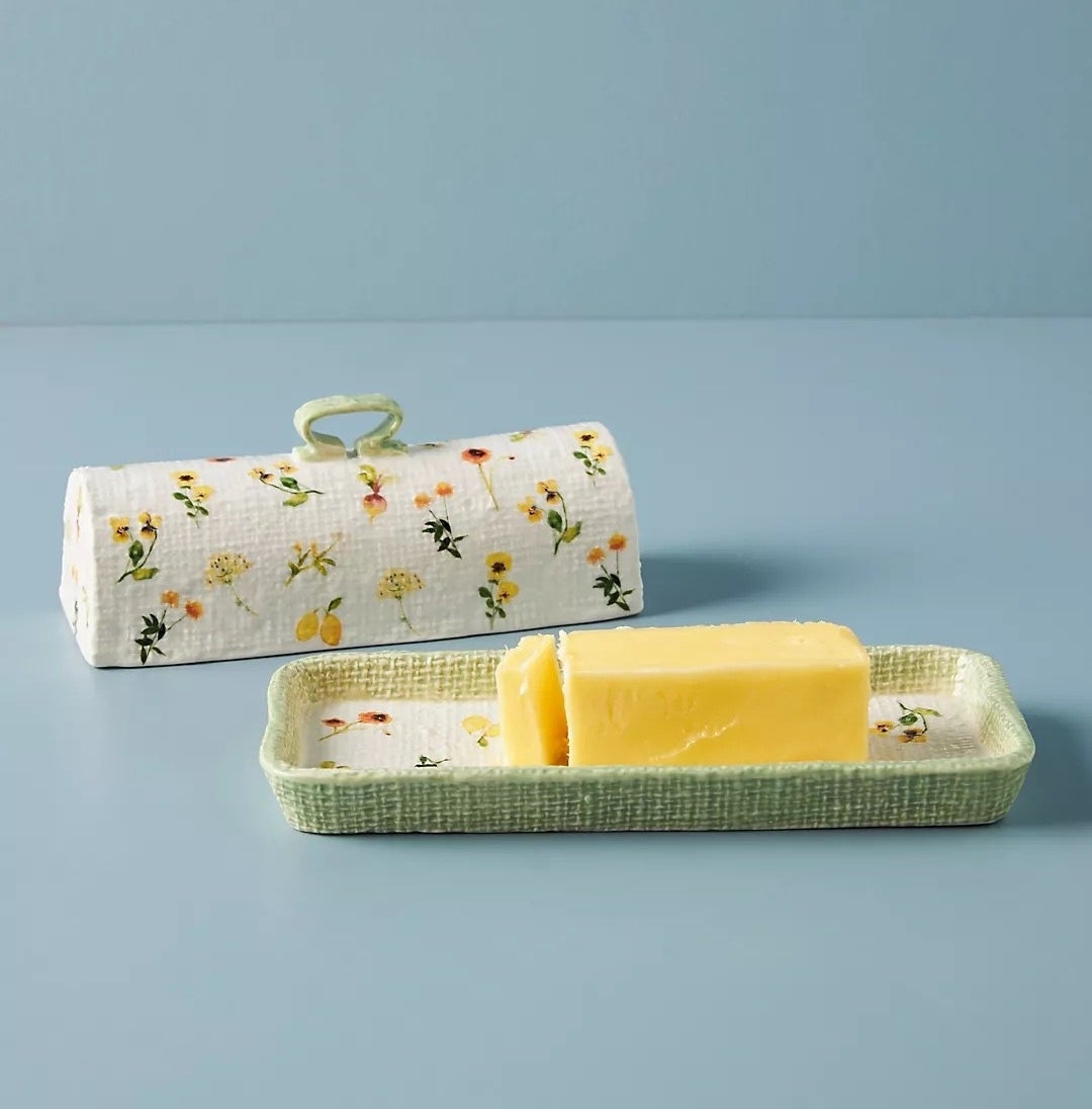 the hand painted butter dish holding a stick of butter