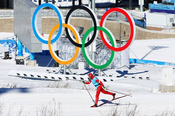 An athlete skis past a Olympic rings logo during the Cross-Country Skiing training session ahead of Beijing 2022 Winter Olympic Games
