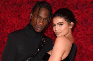 Kylie holds onto Travis while standing in front of a wall of roses