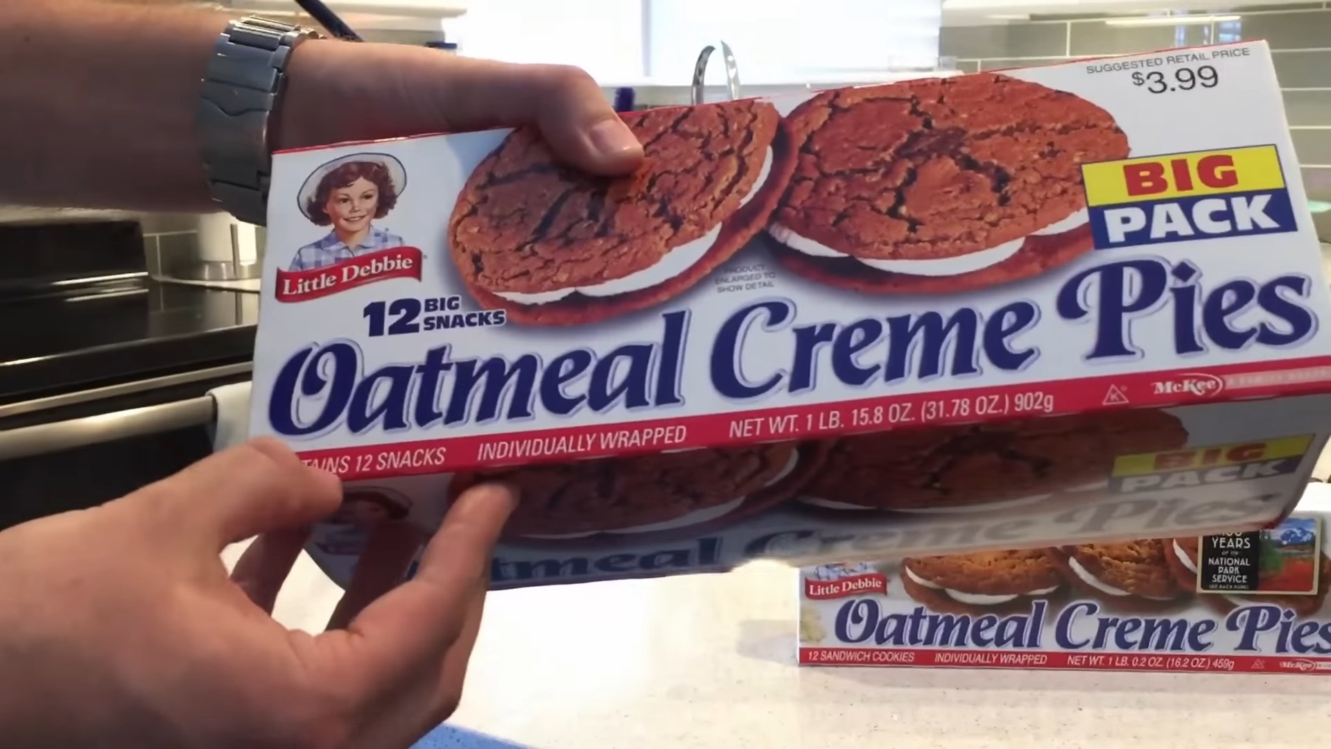 Man holding box of Little Debbie Oatmeal Creme Pies