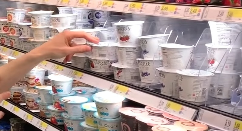 Man picking up yogurt from shelf