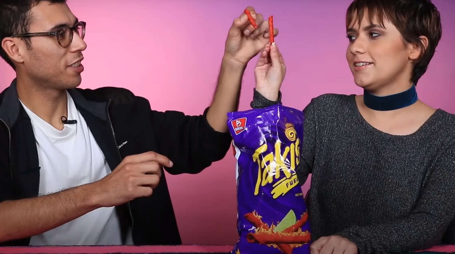 Two people trying Takis Fuego