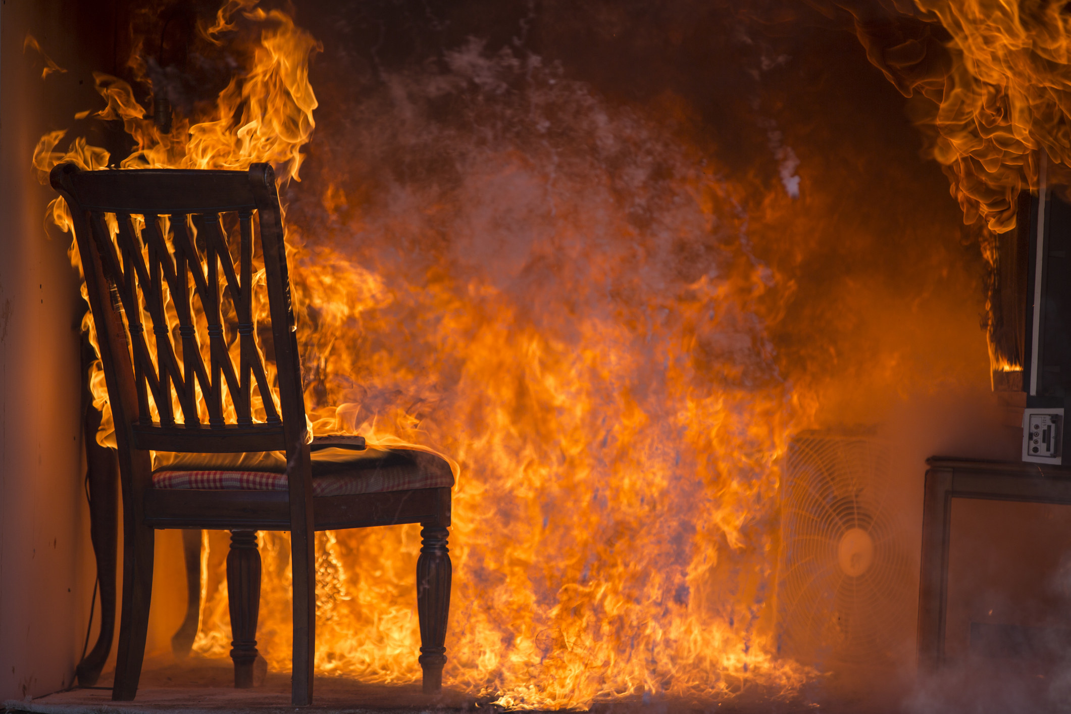 A stock image of a room with a chair on fire