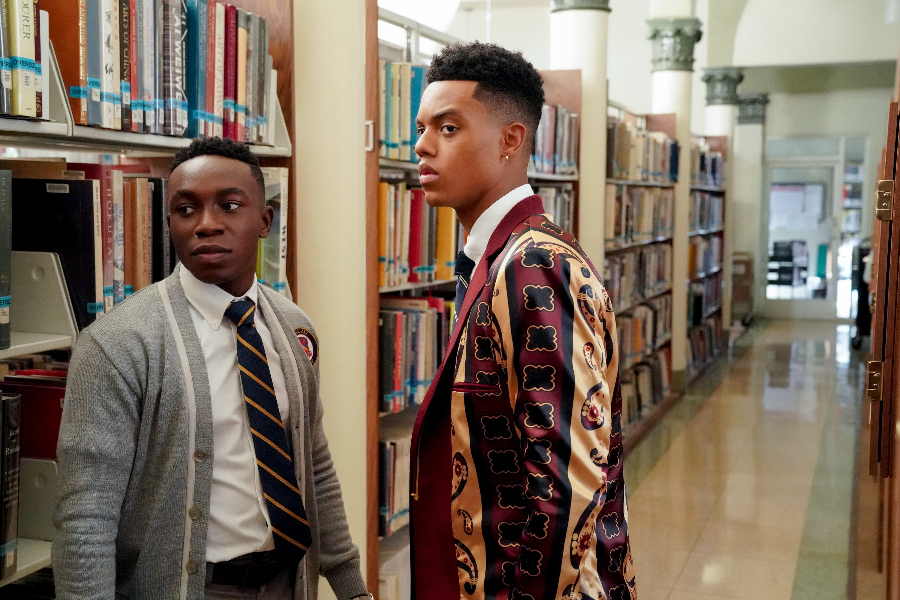 Olly Sholotan as Carlton Banks and Jabari Banks as Will Smith standing in a school library