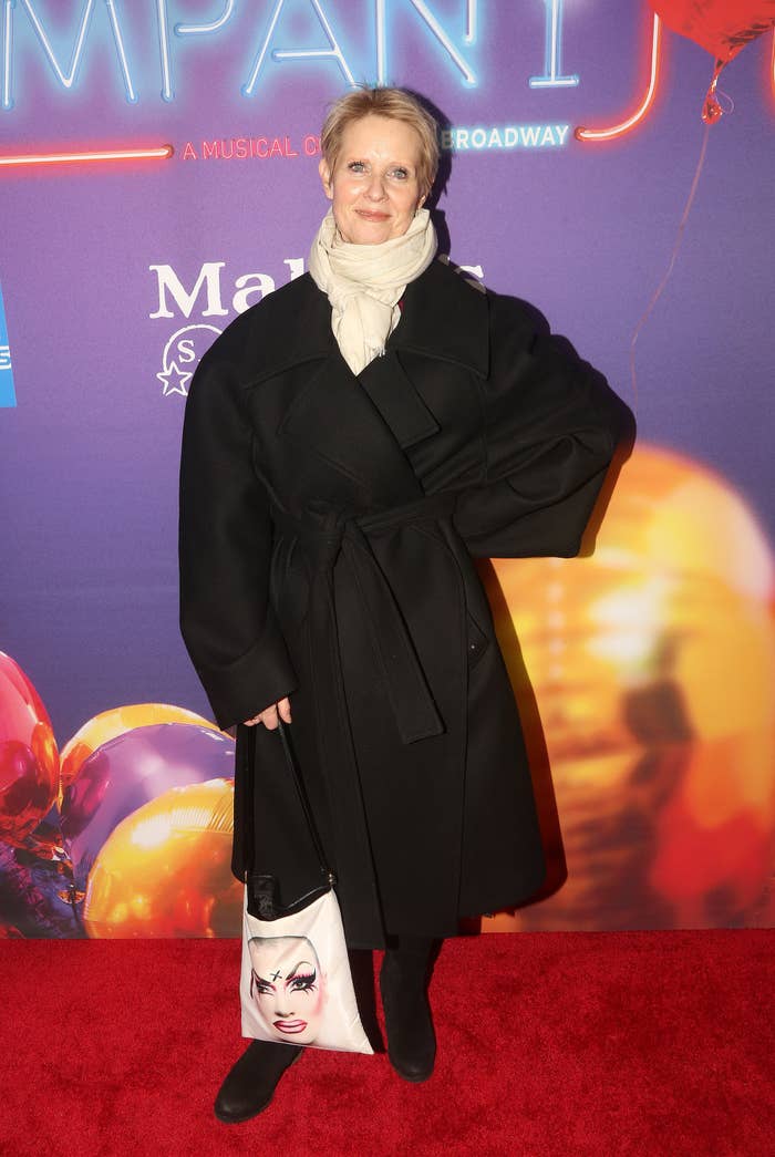 Cynthia smiling as she poses for a photo at a red carpet event