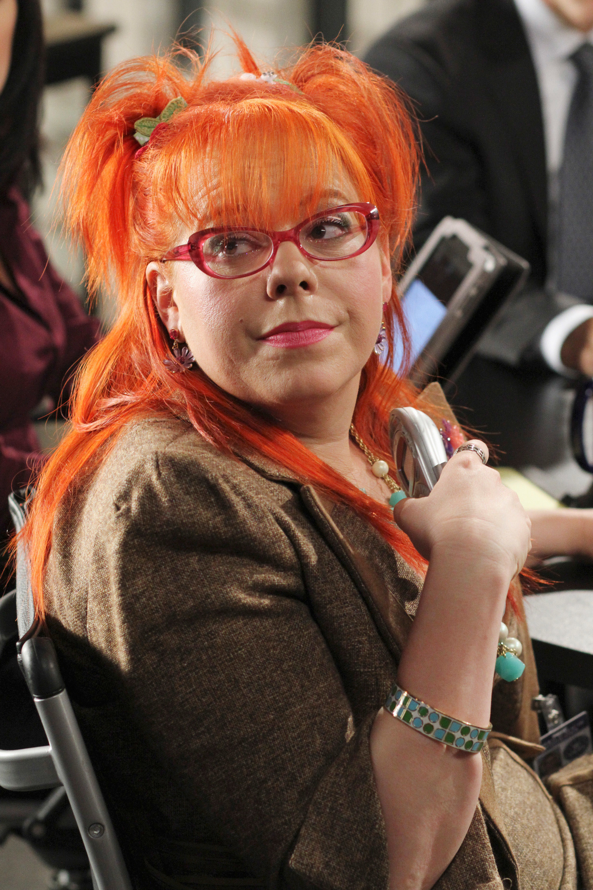 Penelope with bright orange hair and a pink pair of reading glasses
