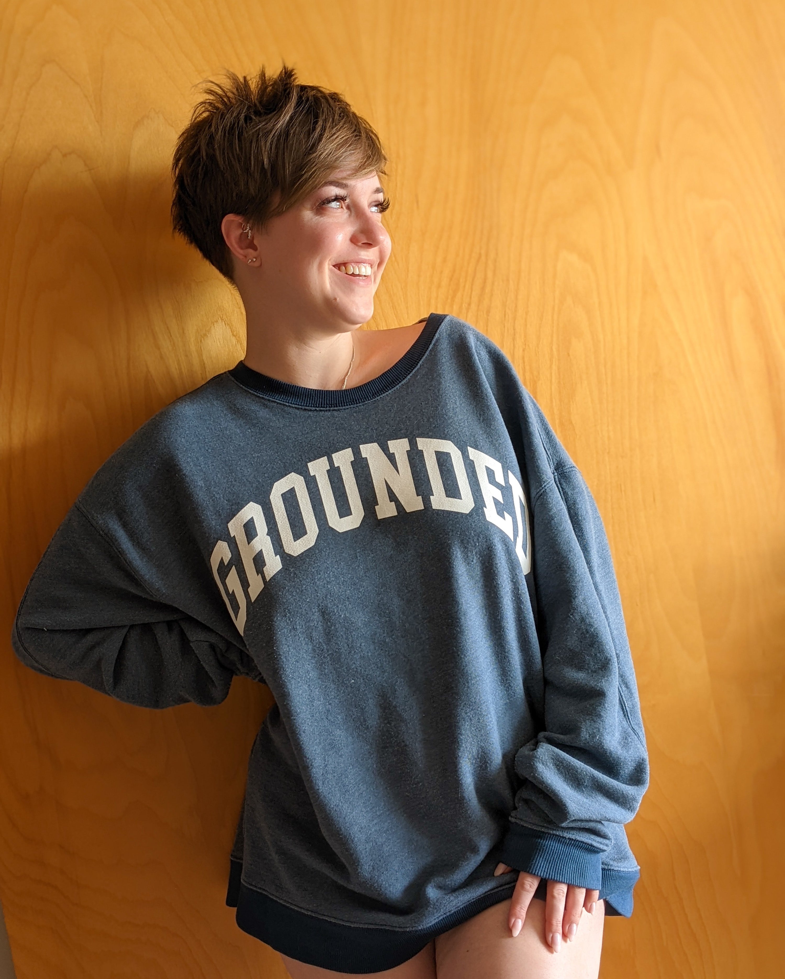 A person wearing the oversized vintage style sweatshirt with the word grounded on the front