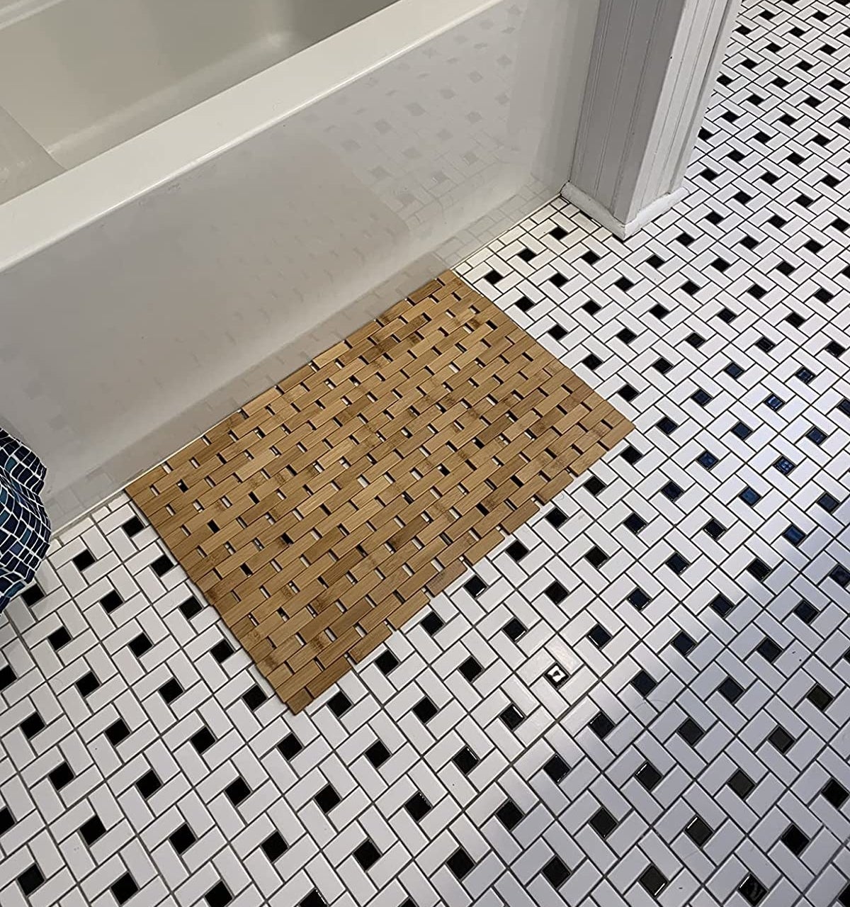 reviewer image of the bamboo mat on the floor of their bathroom