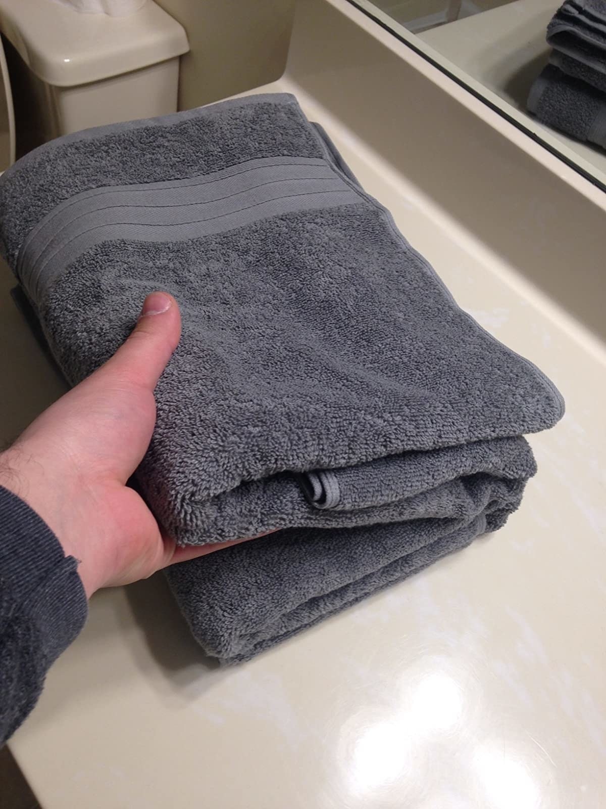 image of reviewer holding a cool grey towel in their hand