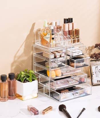 the clear makeup organizer with drawers open and each compartment filled