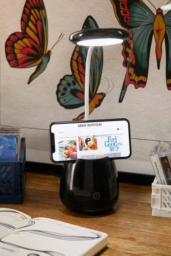 The black table lamp speaker propping up a smartphone