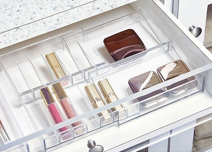 the drawer organizer in a drawer holding cosmetics