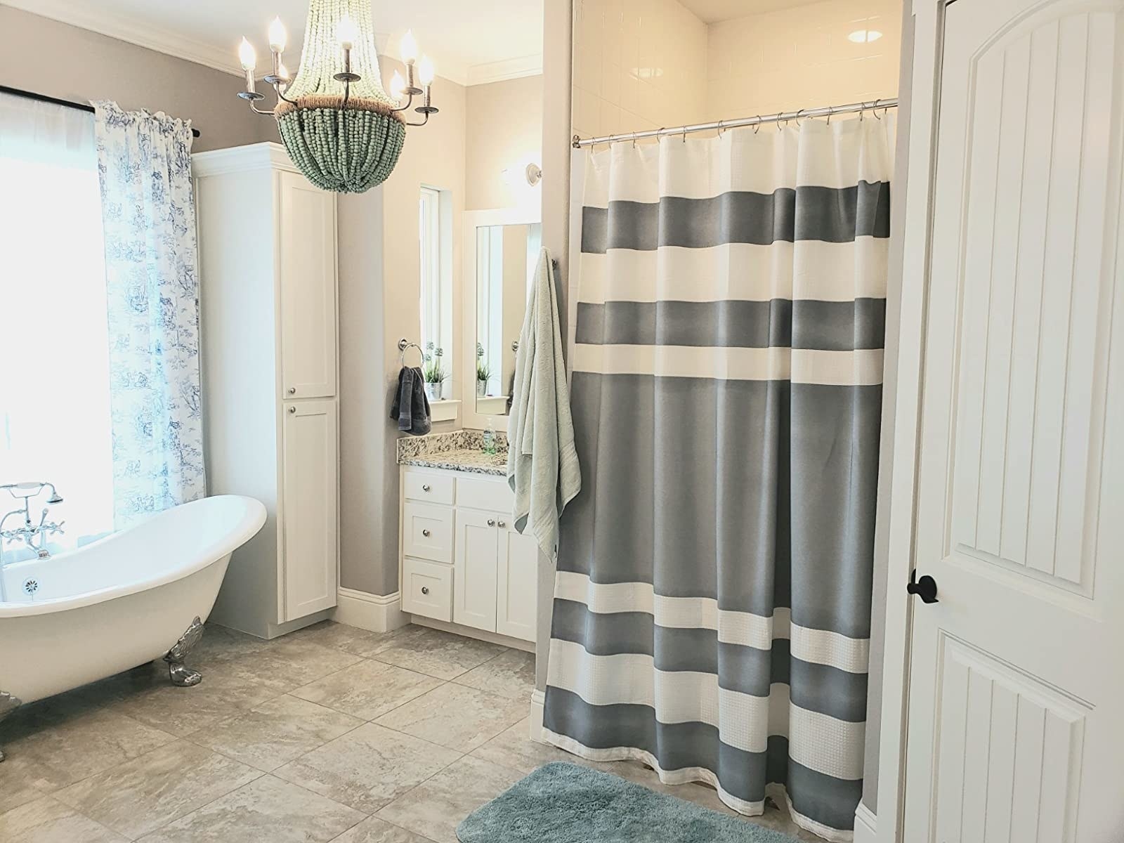 Reviewer photo of their bathroom with a white and grey striped shower curtain