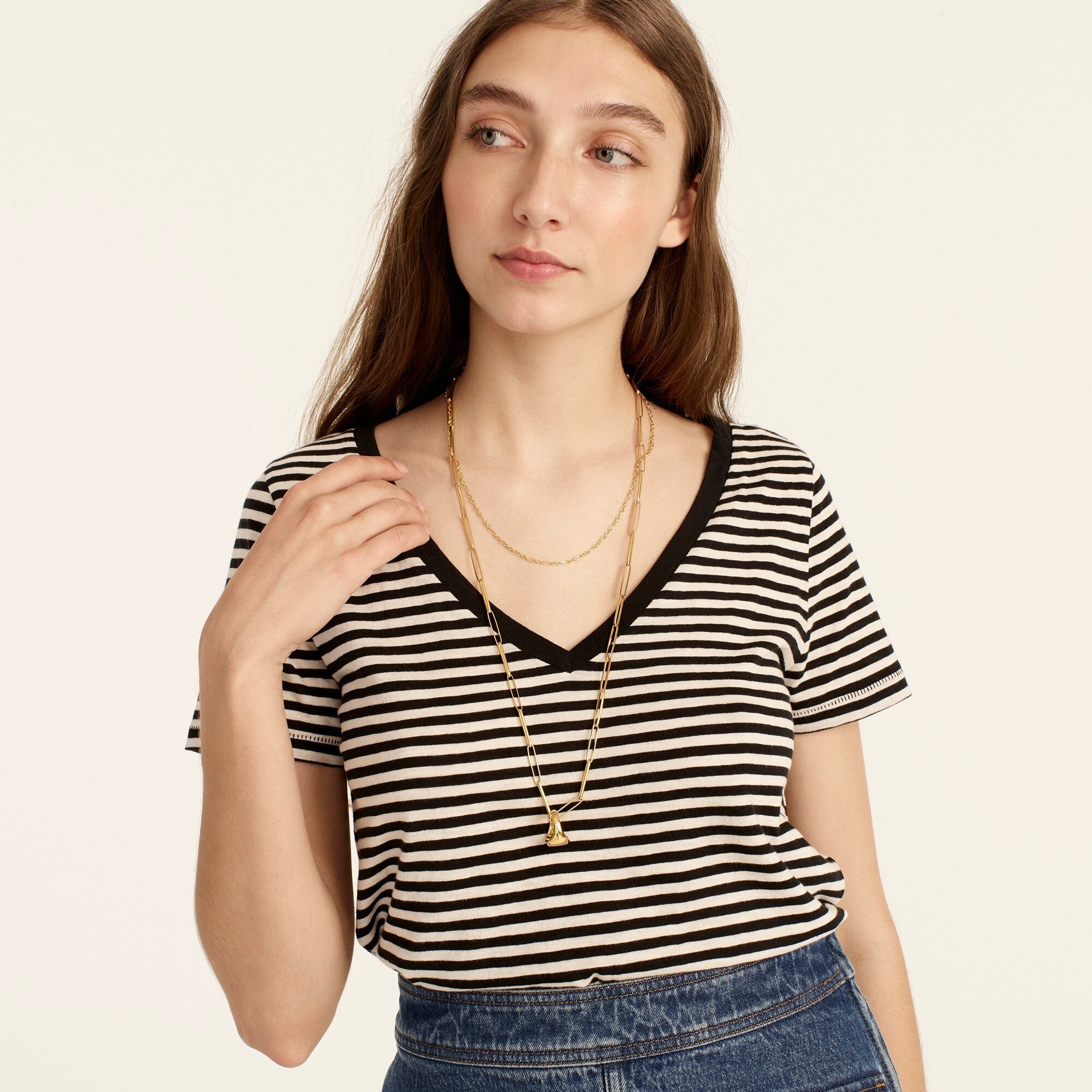 An image of a model wearing a striped, V-neck tee