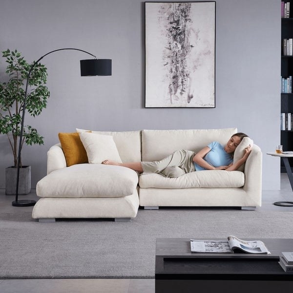 Model is napping on a cream sectional couch
