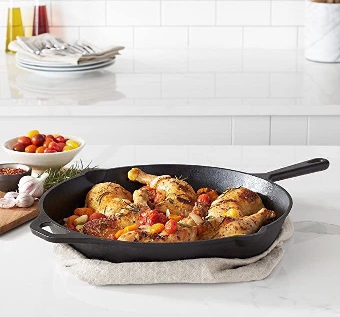 the cast iron skillet with chicken and vegetables inside of it
