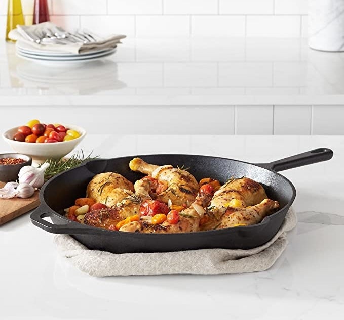 the cast iron skillet with chicken and vegetables inside of it