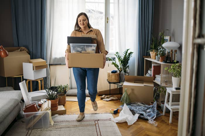 Woman carrying moving boxes into a new apartment
