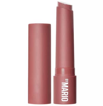 Open pink container of lip stick that reads 