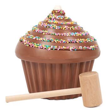 closeup of the cupcake shaped hollow chocolate and a wooden mallet 