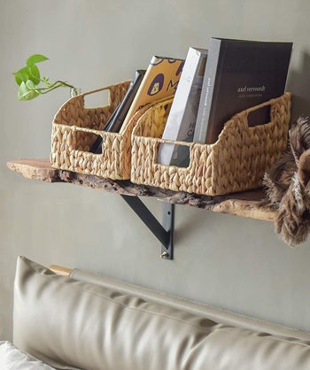 the woven baskets holding books above a bed