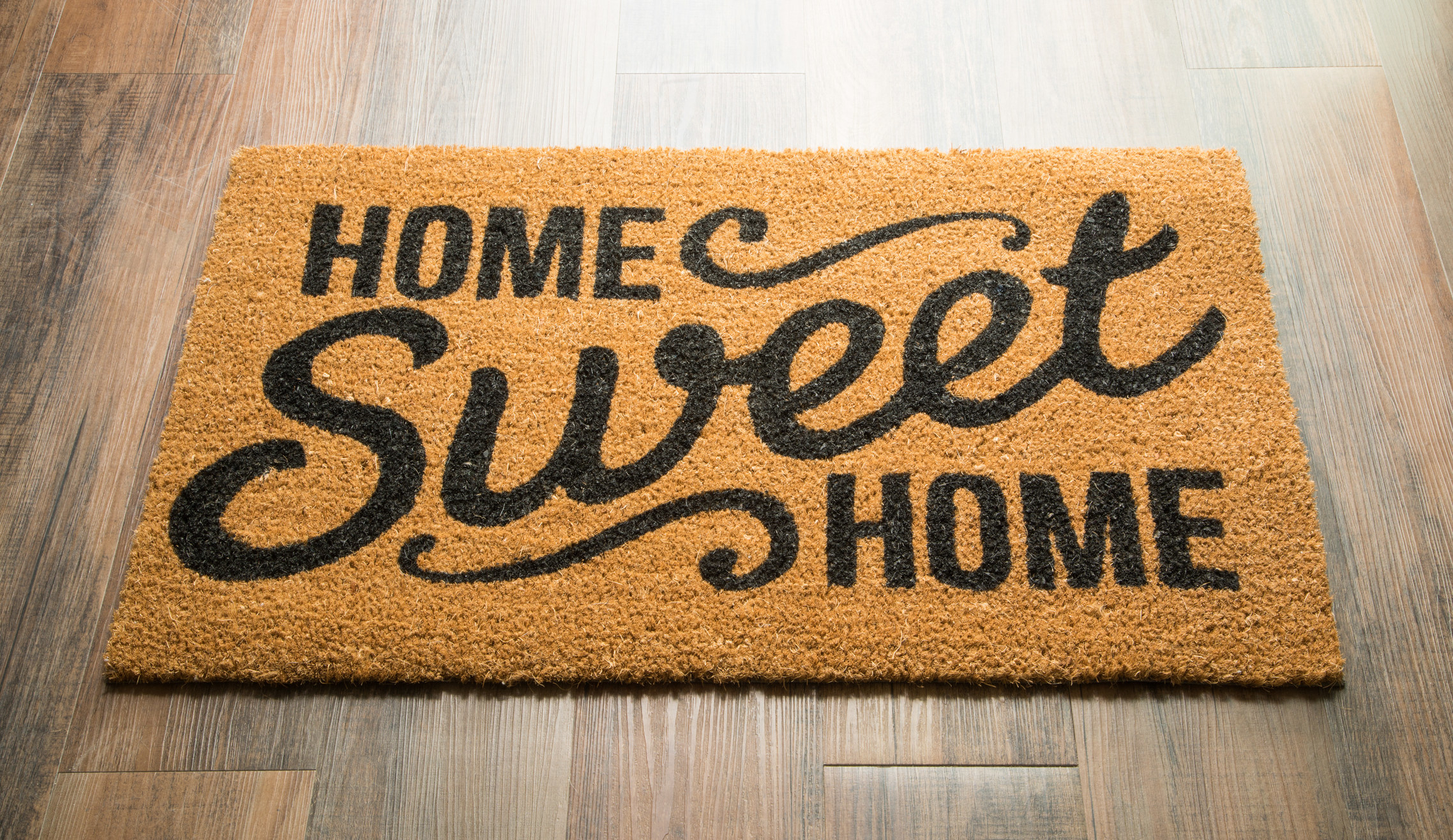 A mat on a floor that says, &quot;Home Sweet Home&quot;