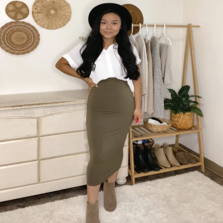 A customer review photo of them wearing the skirt in green with booties and a white T-shirt