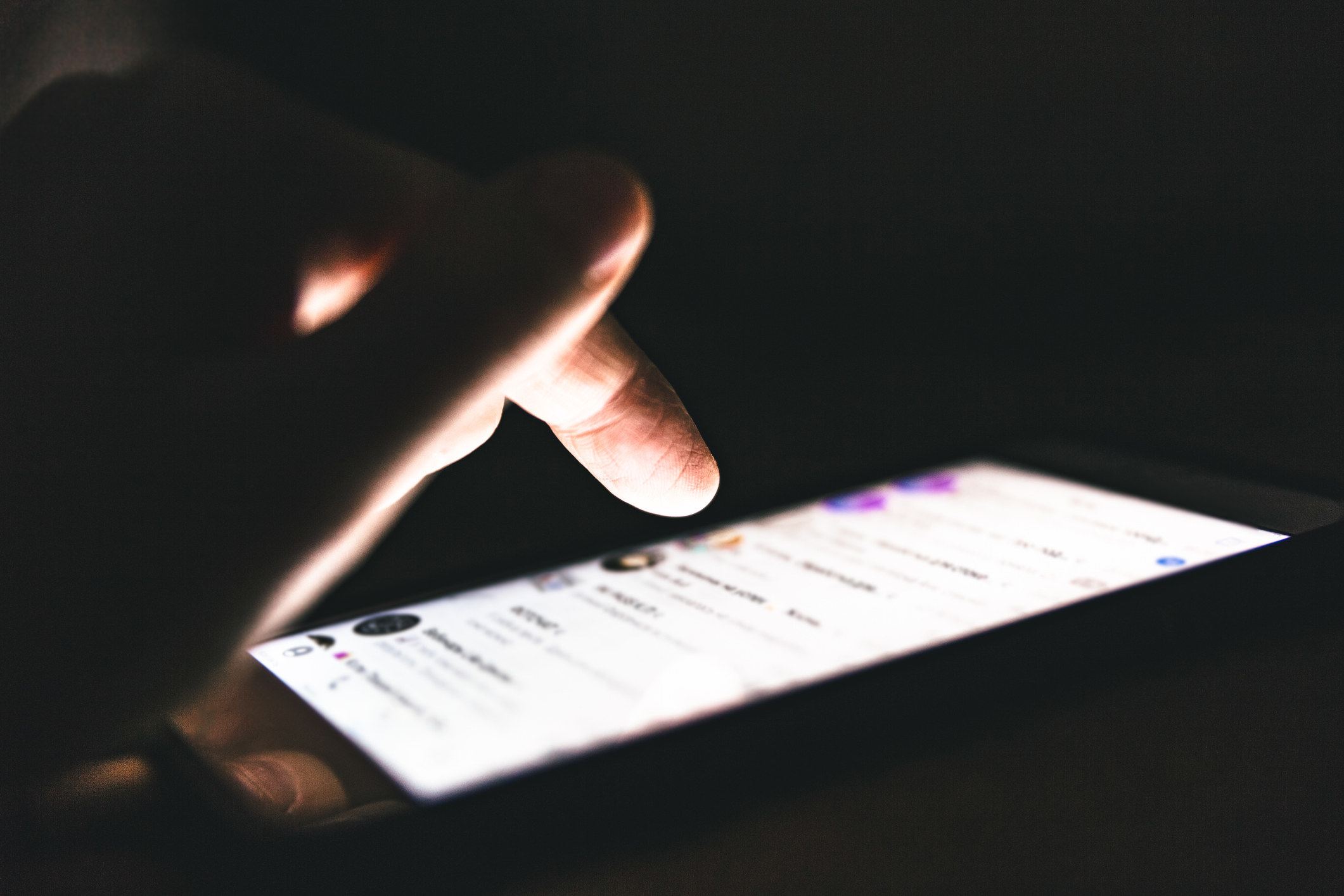 close-up of a hand clicking through a dating app on a smartphone