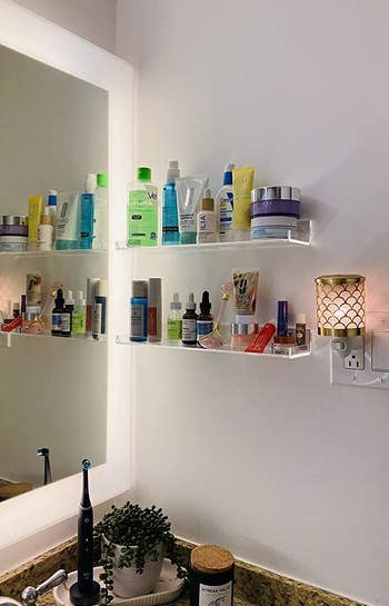 two shelves hung next to sink holding skincare supplies