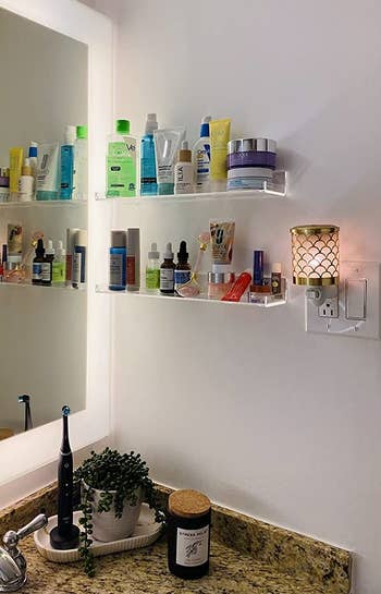 two shelves hung next to sink holding skincare supplies