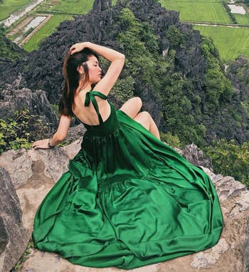 A model wearing the dress in emerald green