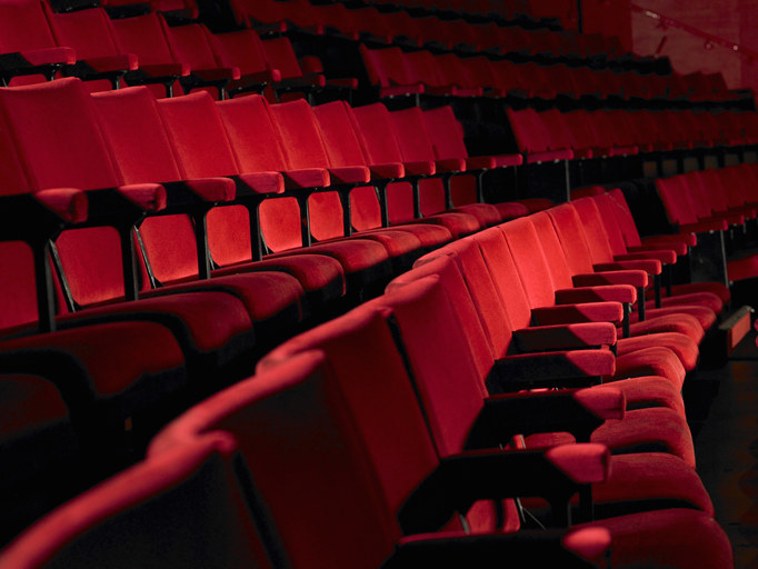 A row of cushioned movie theater seats
